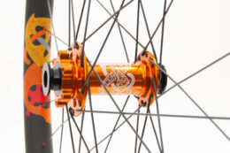 Knarr front wheel with a tangerine orange laser etched hub