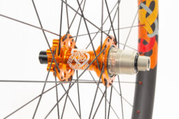 Knarr rear wheel with a tangerine orange laser etched hub